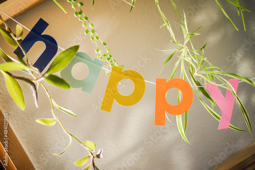 Colorful Happy letters between house plants