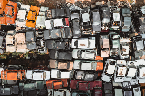Aerial view of a Soviet automobile dump from a drone. Shooting from above at heaps of rusty cars. Abandoned Russian cars awaiting disposal and recycling © xartproduction