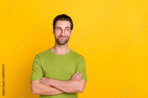 Photo of nice beard millennial guy crossed palms look promo wear spectacles green t-shirt isolated on yellow color background