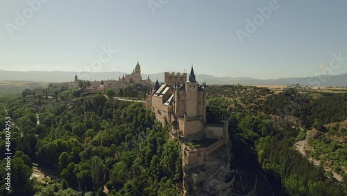 Aerial drone point of view Alcazar of Segovia medieval castle against blue sky during sunny day located in the city of Castile and Leon, Spain. The fortress is a World Heritage Site by UNESCO
