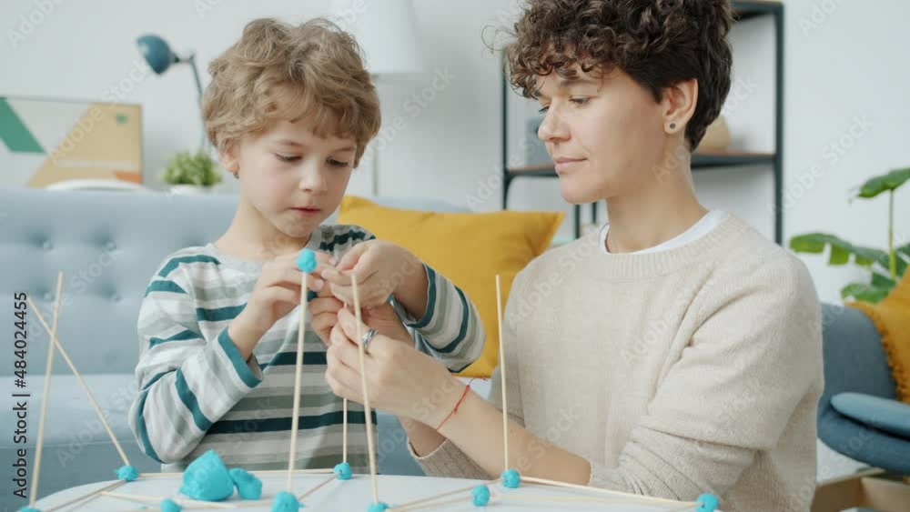Slow motion of caring mother doing craft with kid playing together in apartment during covid-19 social isolation. People and motherhood concept. Slow motion of caring mother doing craft with kid playing together in apartment during covid-19 social isolation. People and motherhood concept.