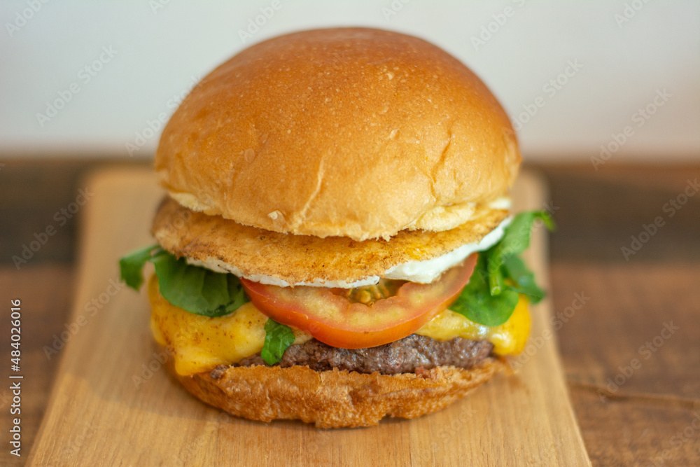 Cheeseburger with bread, fried egg, tomato, arugula, cheese and patty. Cheeseburger with bread, fried egg, tomato, arugula, cheese and patty.