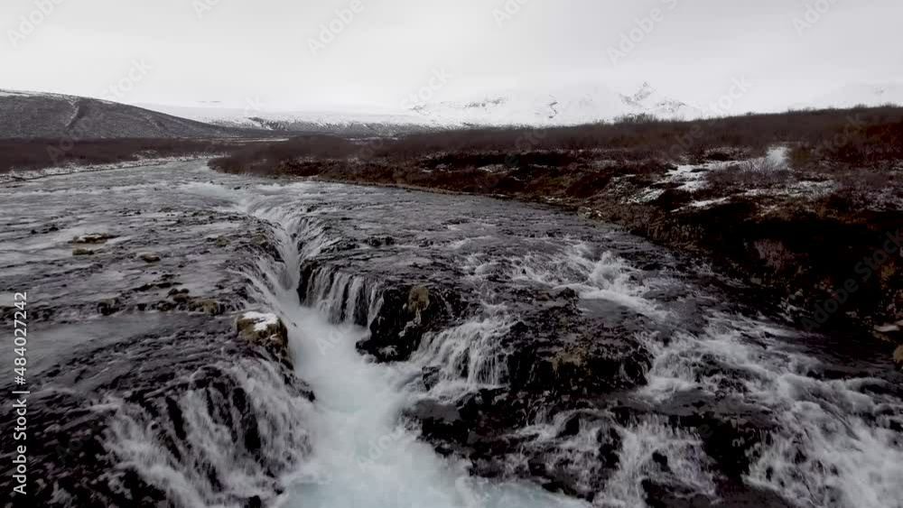 Aerial view of a waterfall in Iceland with snowy beautiful landscape