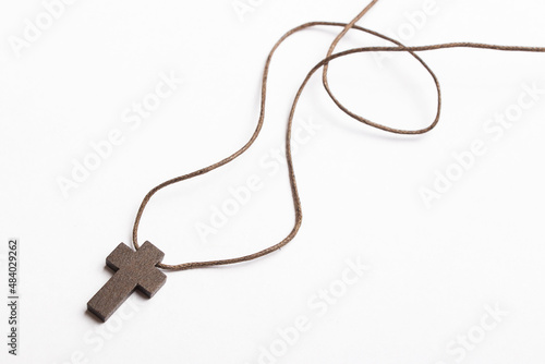 Christian cross isolated on light gray background with free space for writing. Christian cross on craft paper background.