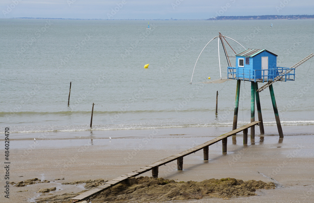 old wooden blue fishing hut on stilts at low tide on the west coast of the atlantic ocean france 