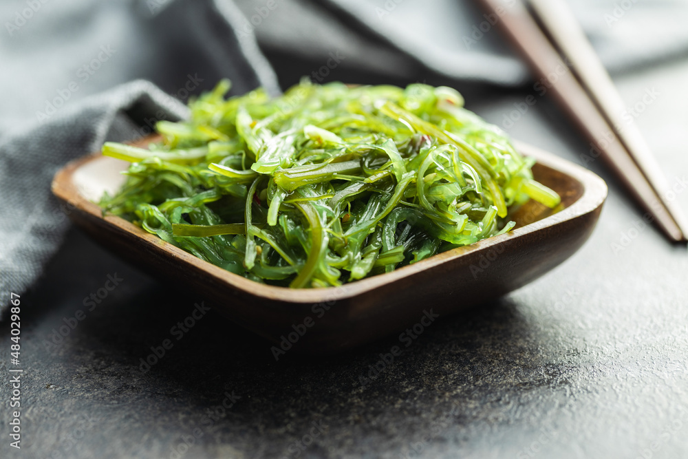 Green wakame. Seaweed salad in wooden bowl. Green wakame. Seaweed salad in wooden bowl.