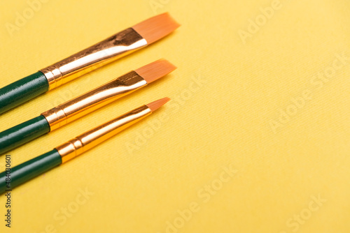 Paint brushes isolated on yellow background. For art
