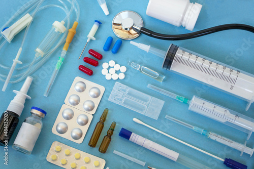 Flat lay of various medical supplies on blue background, copy space