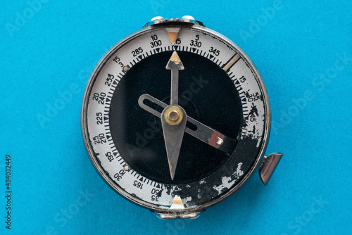 Old soviet compass close-up on a blue background top view isolated photo