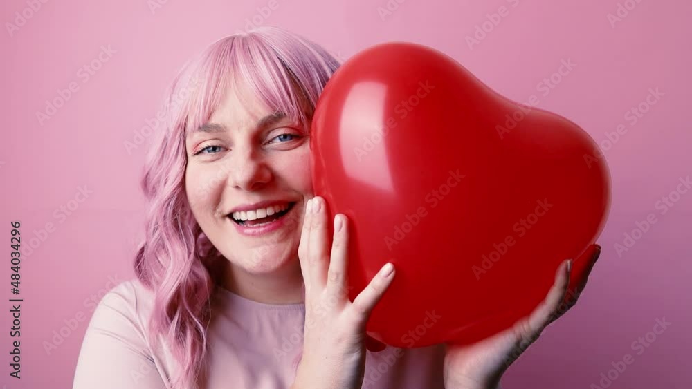 Valentine's day celebration. Young pretty caucasian glamour woman smiling holding red balloon shaped heart isolated on pink background. Valentine's day celebration. Young pretty caucasian glamour woman smiling holding red balloon shaped heart isolated on pink background.