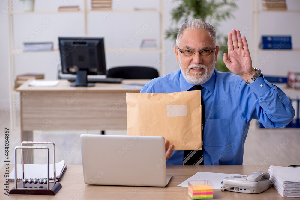 Old male employee receiving parcel via Internet Old male employee receiving parcel via Internet
