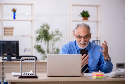 Old male bookkeeper working in the office