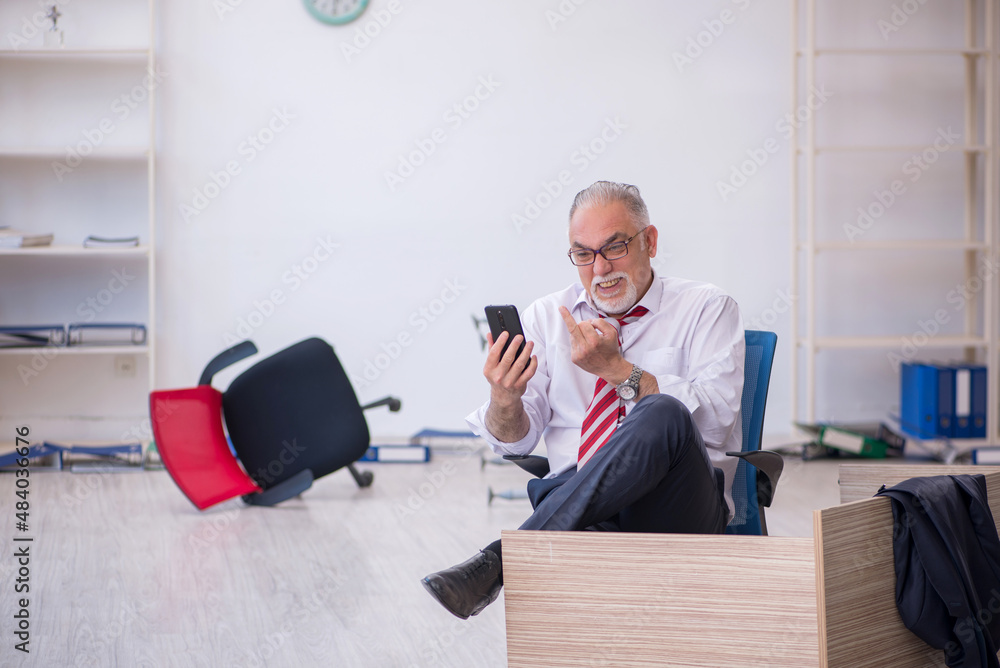 Old male employee working overtime in the office Old male employee working overtime in the office