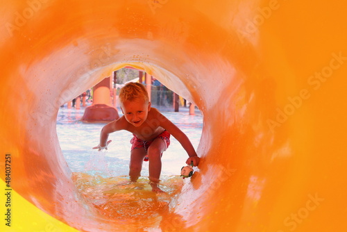 A boy is cheerful playing in the pool at the water park in the summer on a sunny day selective focus. © Olga