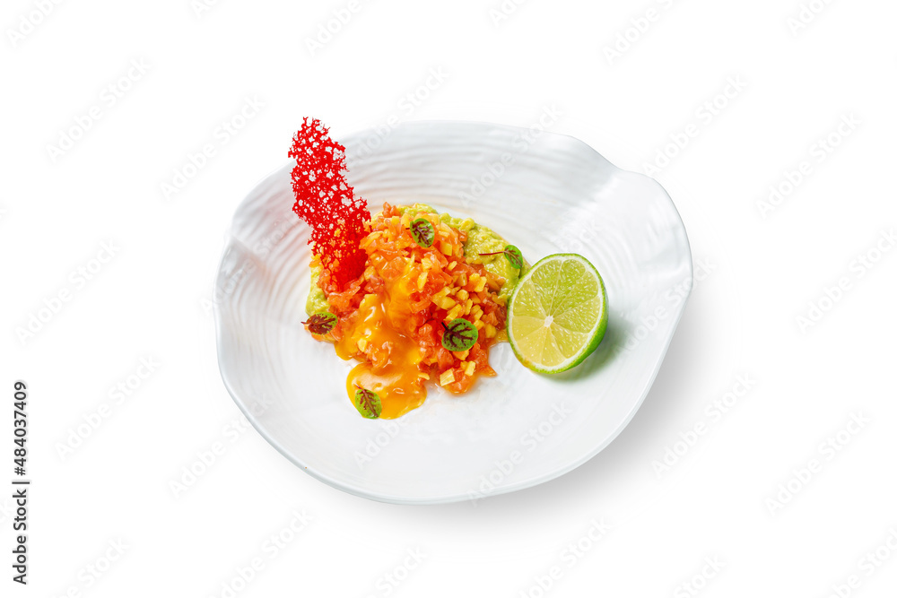 Mango and salmon salad with sauce and avocado puree with lime and young beet leaves garnished with isomalt on a plate on a white isolated background Mango and salmon salad with sauce and avocado puree with lime and young beet leaves garnished with isomalt on a plate on a white isolated background