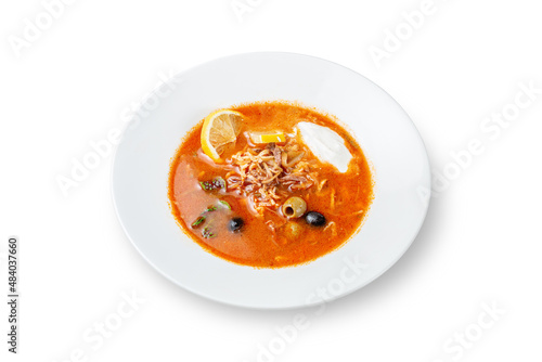 Hot Dishes. Hodgepodge with olives, sour cream and lemon in a plate on a white isolated background photo