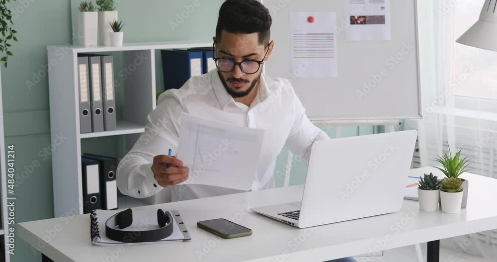Businessman working on laptop and analyzing document at office Businessman working on laptop and analyzing document at office