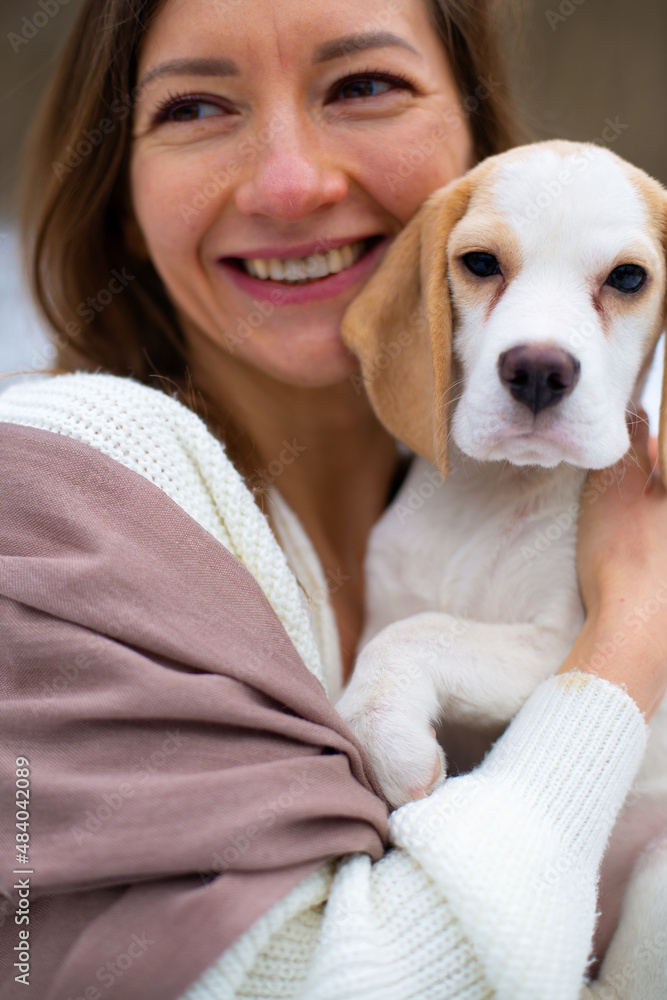 woman in scarf hugs with cute beagle puppy in the snowy winter forest woman in scarf hugs with cute beagle puppy in the snowy winter forest