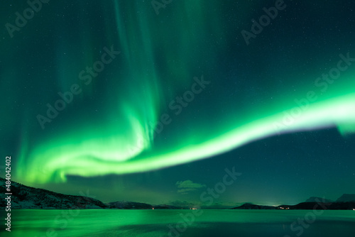 Long green leading line of aurora across the night sky