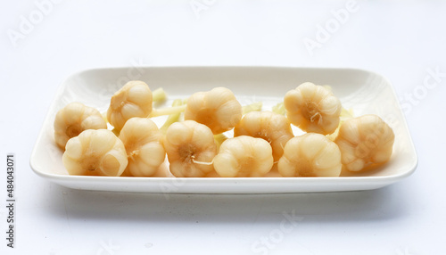 Pickled garlic in plate on white background.