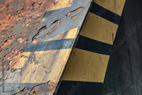Alte, verrostete Metallkonstruktion mit Bauarbeiten-Warnfarben in Schwarz und Gelb