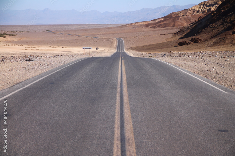 The straight and long street in the middle of the Death Valley desert
