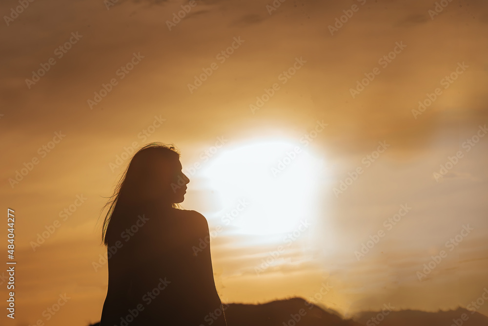 Young beautiful girl with long hair in the rays of the setting sun in the warm season. selective focus . Young beautiful girl with long hair in the rays of the setting sun in the warm season. selective focus .