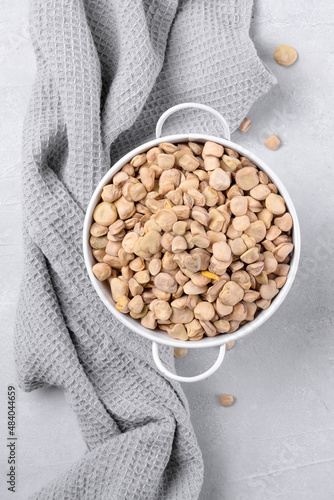 Cicerchia or indian pea in a white bowl with napkin on grey table background, gluten free food. Legumes known as Lathyrus Sativus, Chickling Vetch, Blue Sweet Pea made in Puglia, top view, close up photo