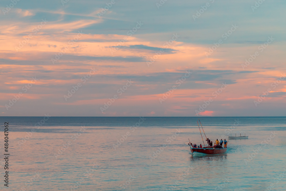 Fishing boat with fisherman return home, Indian ocean on a scenic sunset. Zanzibar, Tanzania