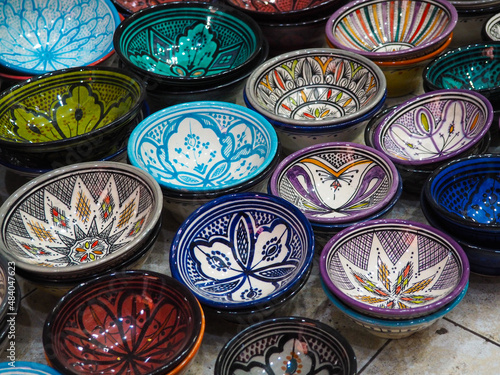 Handmade colourful decorated bowls or cups on display at traditional souk - street market in Morocco
