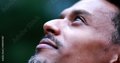 African american man face closing eyes feeling spiritual contemplating and celebrating life. Black person opening eyes to sky