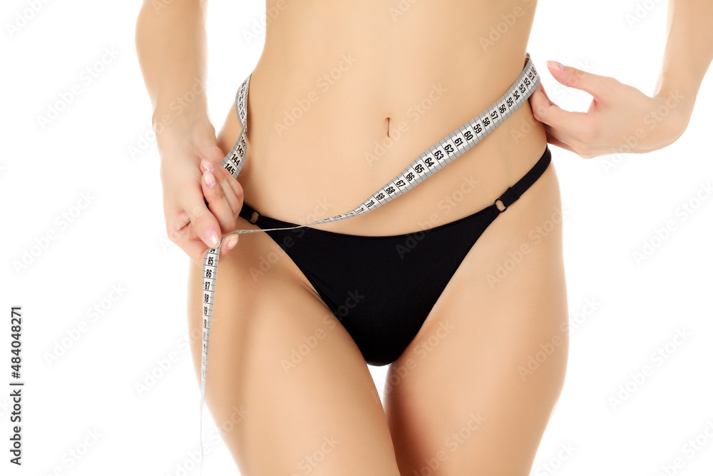 Woman with broad thighs measures her waist