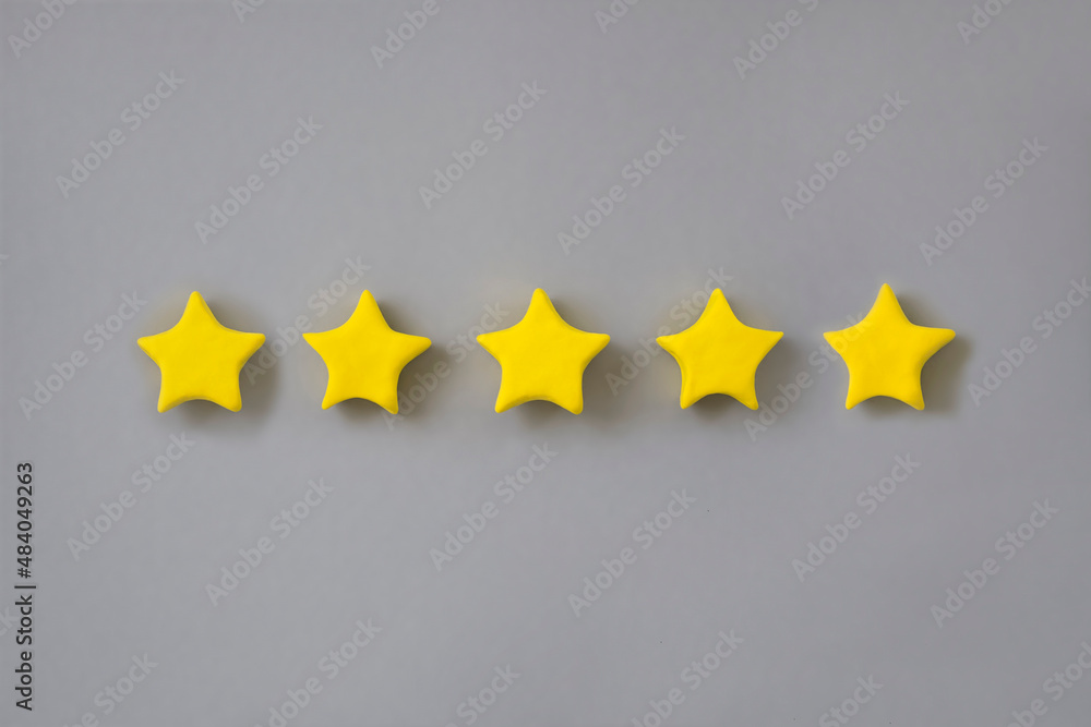 Five star in a row on grey background. Golden star shape. Concept of top class, best quality product symbol. Sign of evaluation, feedback from customer. Five star in a row on grey background. Golden star shape. Concept of top class, best quality product symbol. Sign of evaluation, feedback from customer.
