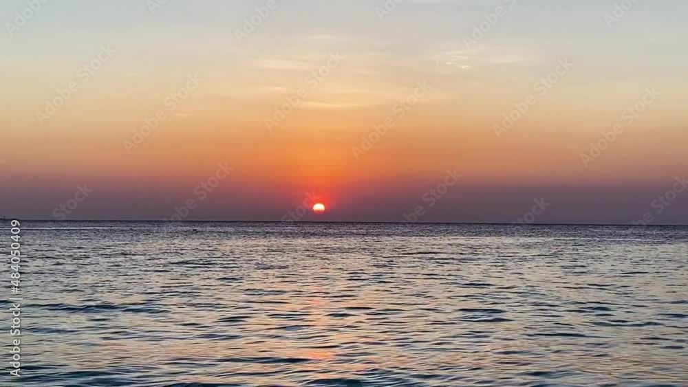 Sunset on the horizon of the Indian ocean with small waves and small boats floating. Sunset on the horizon of the Indian ocean with small waves and small boats floating.
