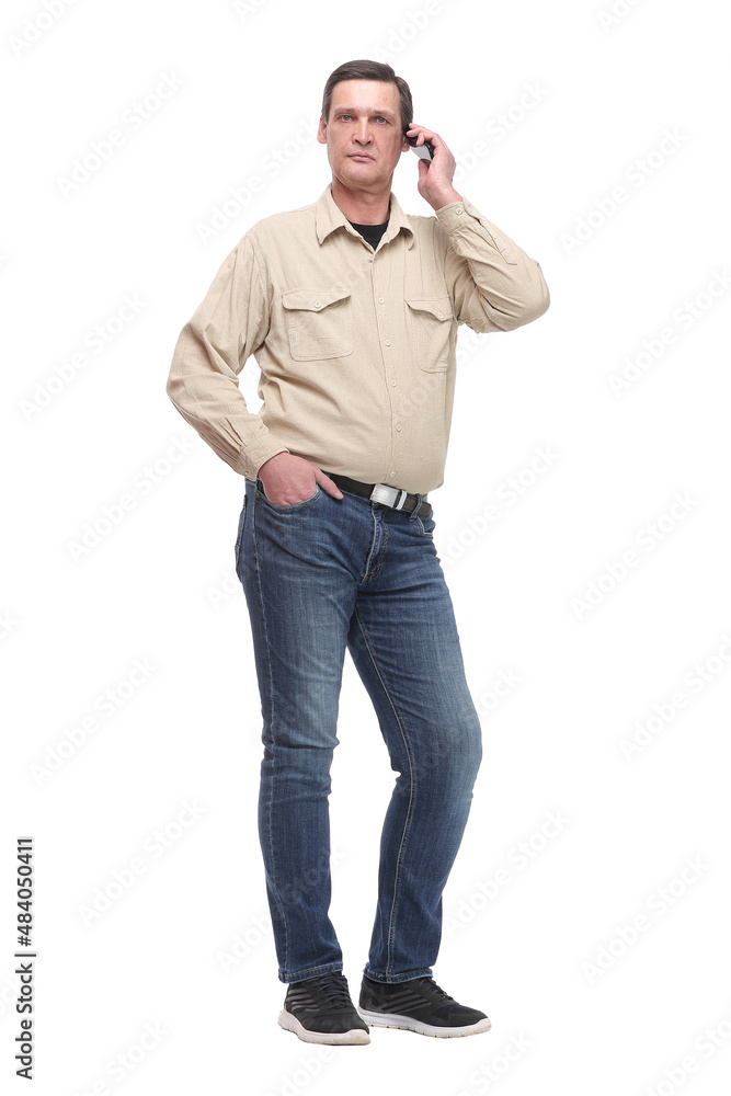 Serious young casual man standing with a hand in his pocket and speaking on the phone Serious young casual man standing with a hand in his pocket and speaking on the phone