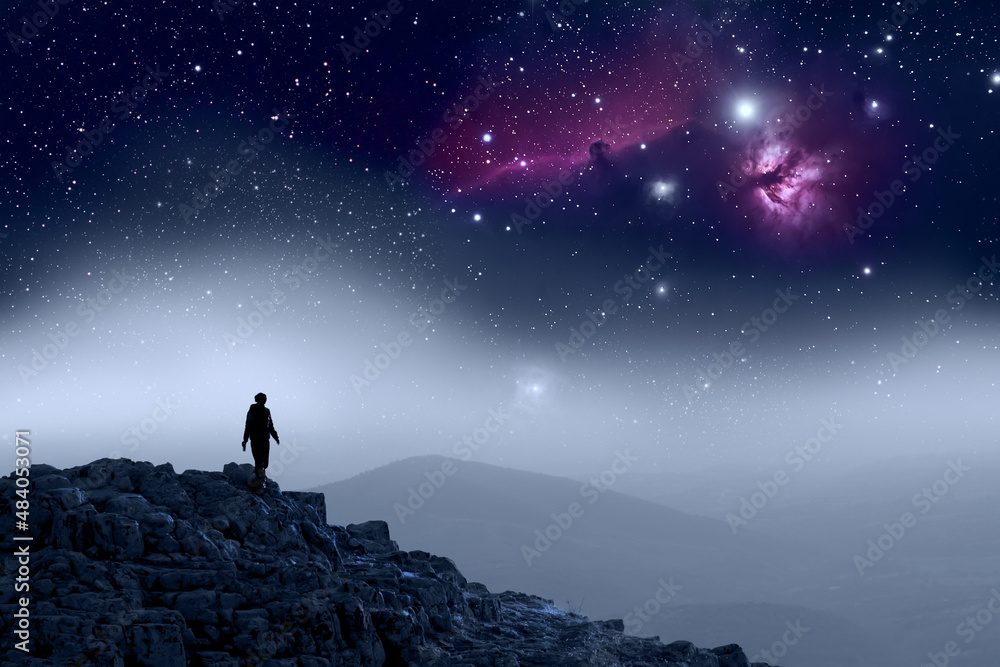 Fototapeta premium Human Silhouette walking on top of mountain, galaxy sky. Astronomy 
