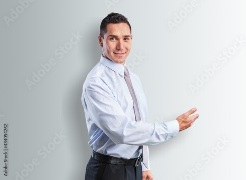 Portrait of attractive glad cheerful man demonstrating ad copy space