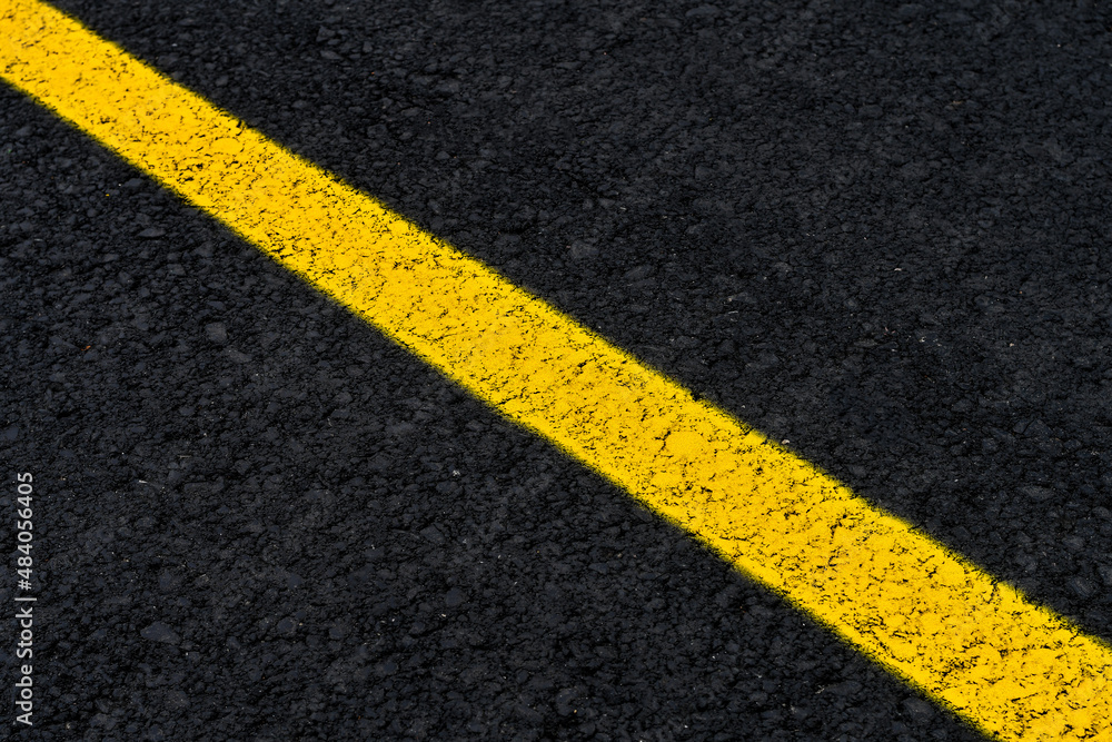 Yellow line on fresh asphalt to mark road works or temporary obstruction. 