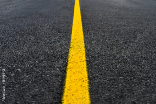Yellow line on fresh asphalt to mark road works or temporary obstruction.  © kyrychukvitaliy