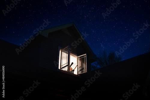 a child pointing to the stars from his bedroom window photo