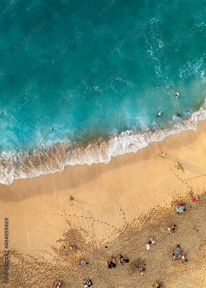 Perfect beach with people tanning and swimming in turquoise ocean , aerial shot from above