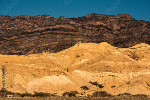 Ranges in Contrast.  In northern Death Valley, the striated Grapevine mountain range forms a backdrop for golden yellow hills of the Furnace Creek formation.