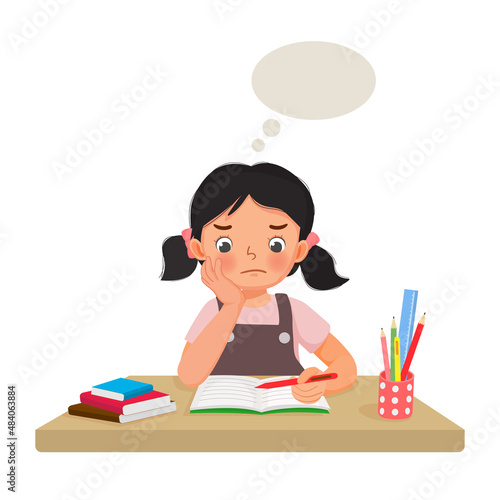 little girl feeling tired, bored, lazy studying and doing math homework at the desk at home