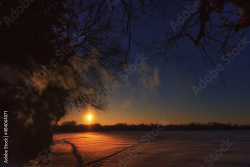 Winter sunrise over a frozen lake 