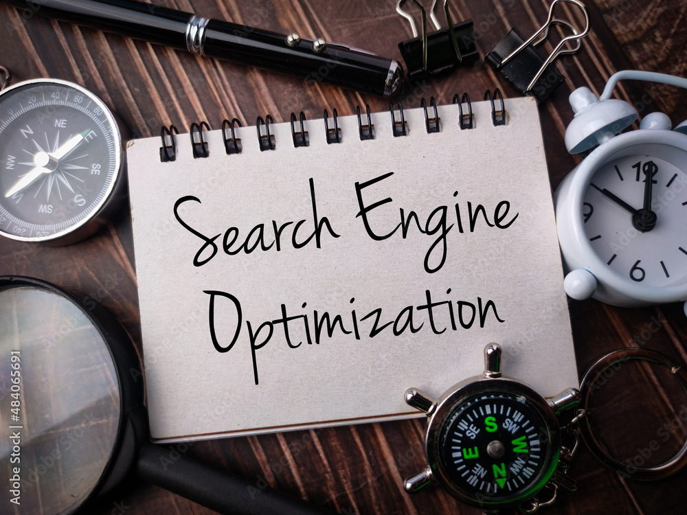 Top view compass,clock,magnifying glass,pen and notebook with text Search Engine Optimization on wooden background. Top view compass,clock,magnifying glass,pen and notebook with text Search Engine Optimization on wooden background.