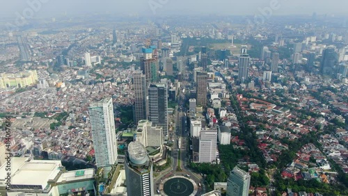 Drone view of Jakarta city with Hotel Indonesia roundabout in central business district, Indonesia. Aerial forward photo