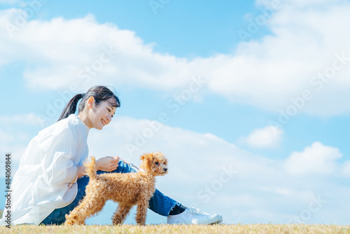 Photographie 愛犬と遊ぶ女性（芝生・座る）