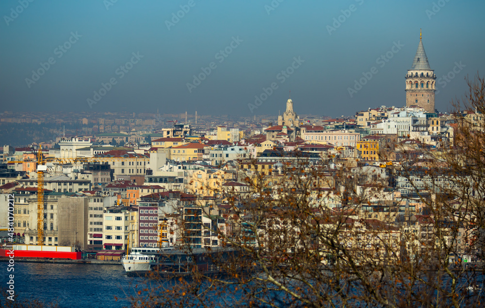 Picturesque view of modern cityscape of Beyoglu district of Istanbul with Galata Tower across Golden Horn in winter, Turkey