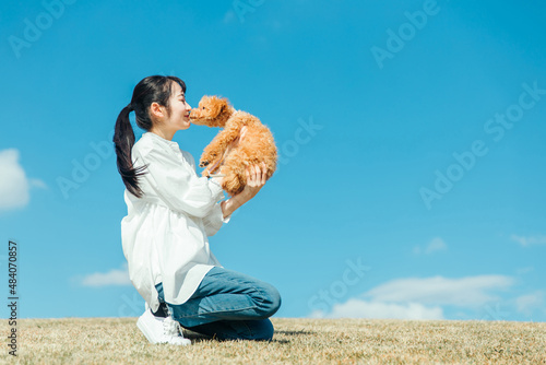 愛犬と遊ぶ女性（キス）
 photo