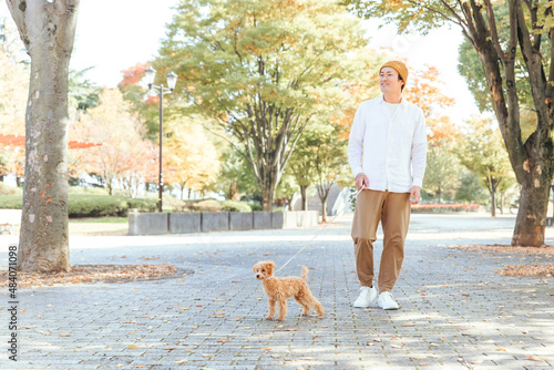 公園で犬と遊ぶ男性（全身）
